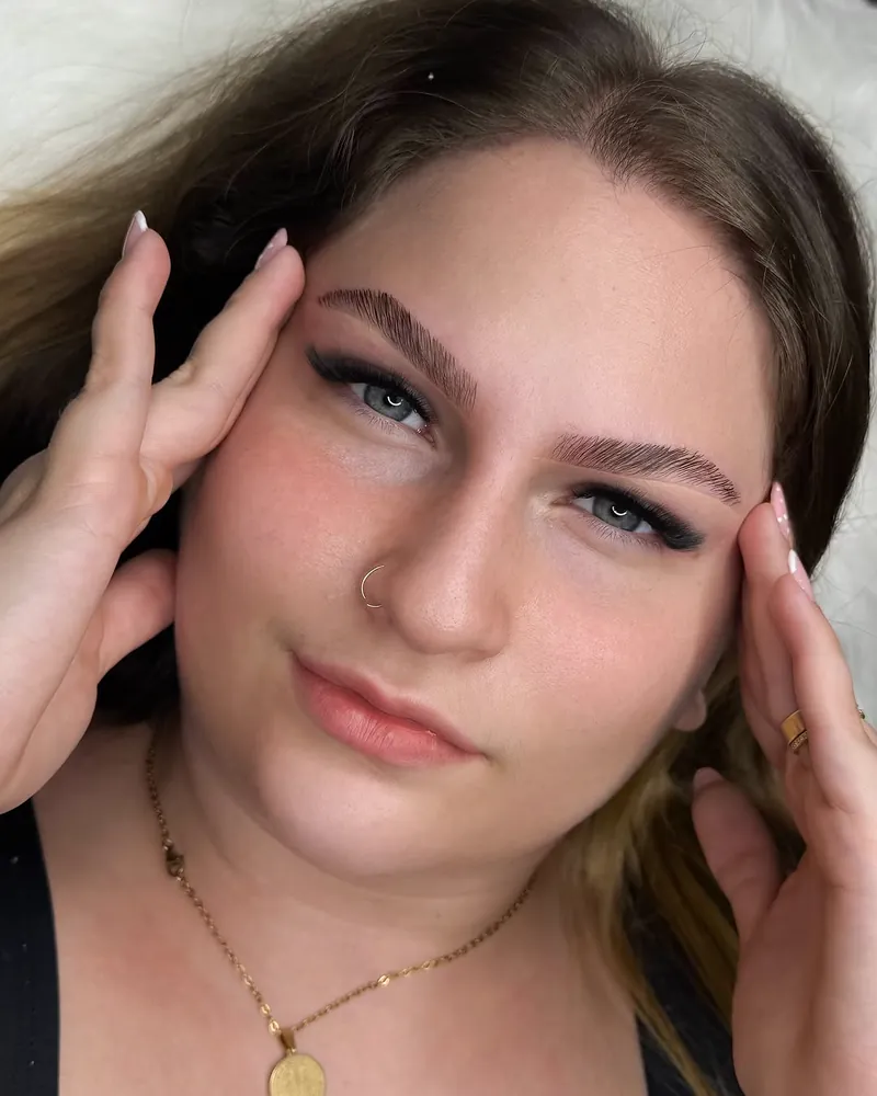 Cliente de olhos claros com sobrancelhas alinhadas após brow lamination