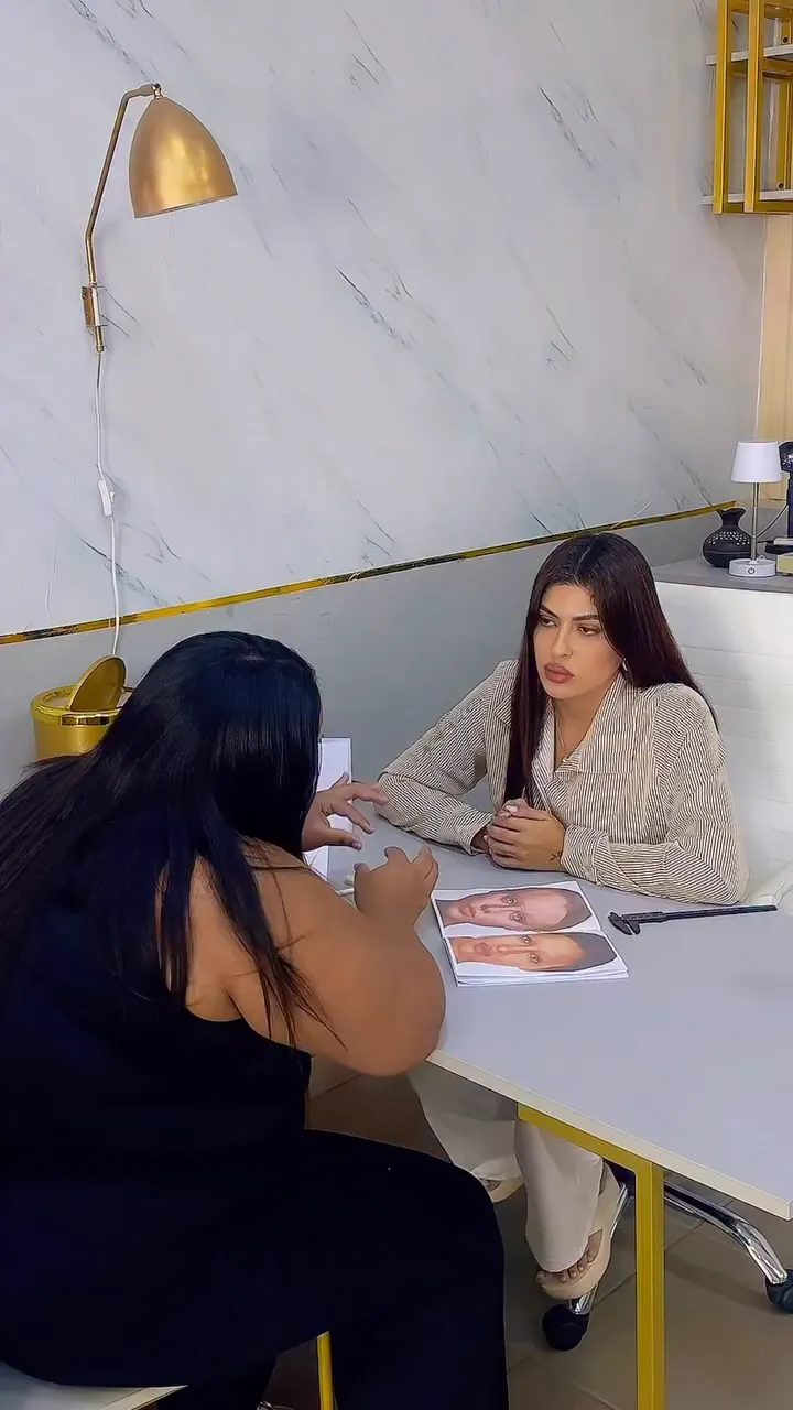 Aula do curso: aluna treinando o desenho de sobrancelhas em fichas de rosto, com a Danny acompanhando à mesa