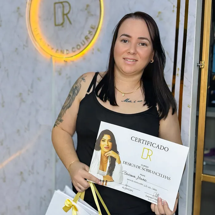 Nova designer de sobrancelhas segurando o certificado no studio
