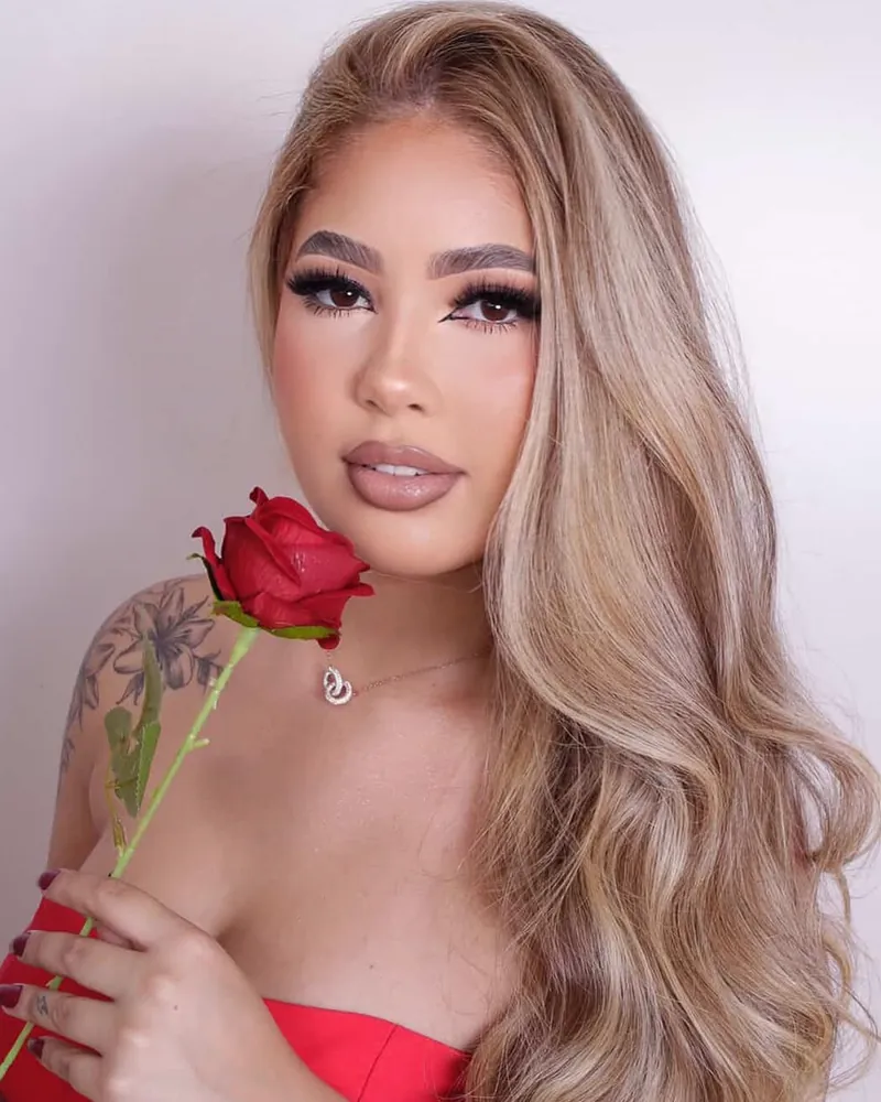 Cliente loira segurando uma rosa vermelha, com micropigmentação shadow