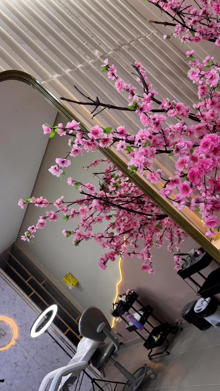 Interior do studio com árvore de flores de cerejeira rosa e iluminação dourada