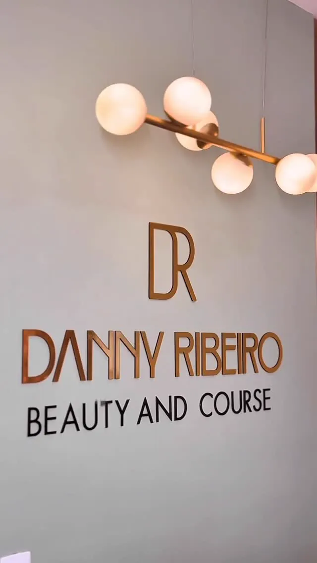 Parede do studio com o logo DR Danny Ribeiro Beauty and Course em letras de cobre